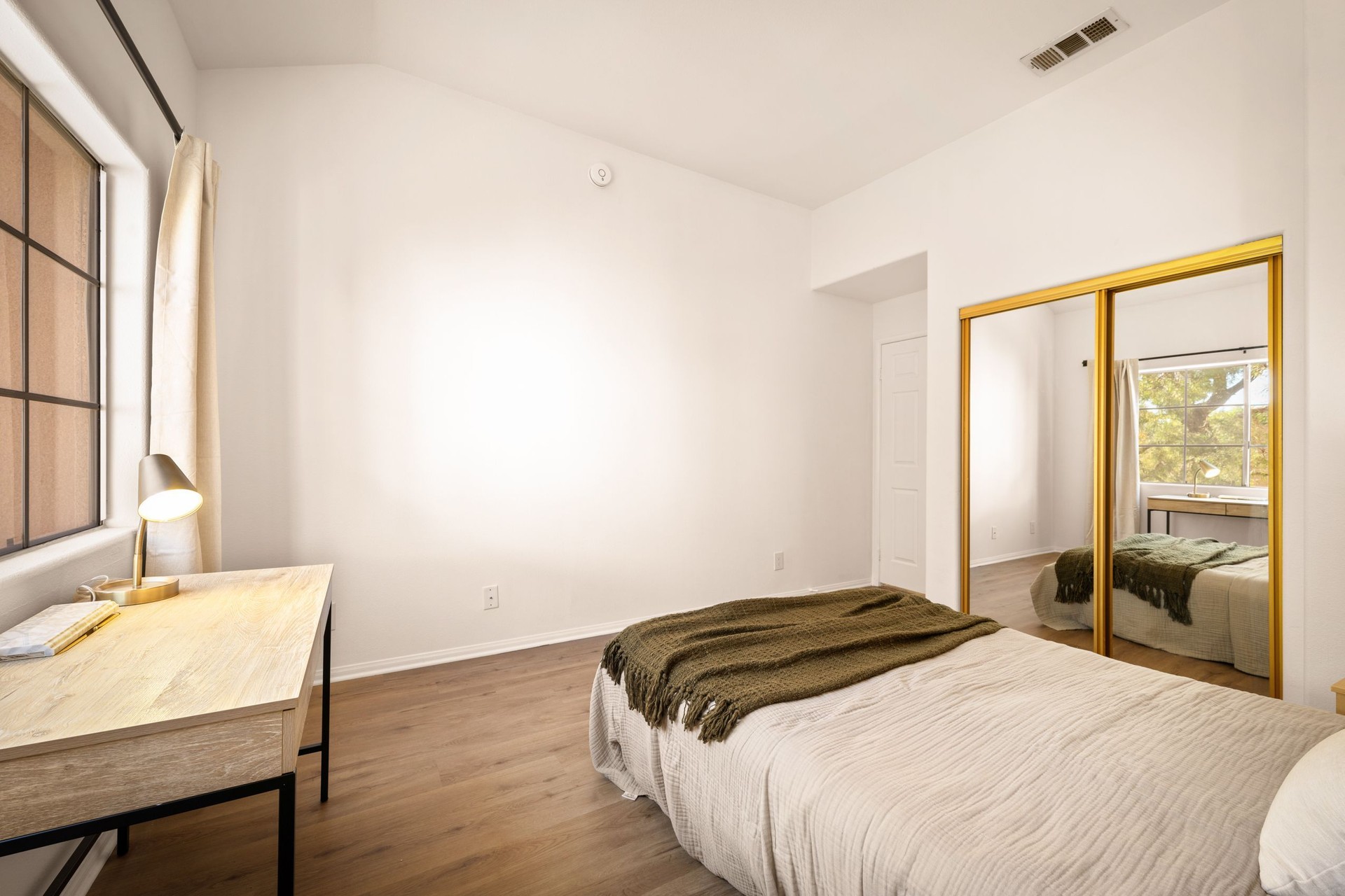 Bedroom with neutral tones, large windows, modern decor, soft lighting, and cozy furnishings